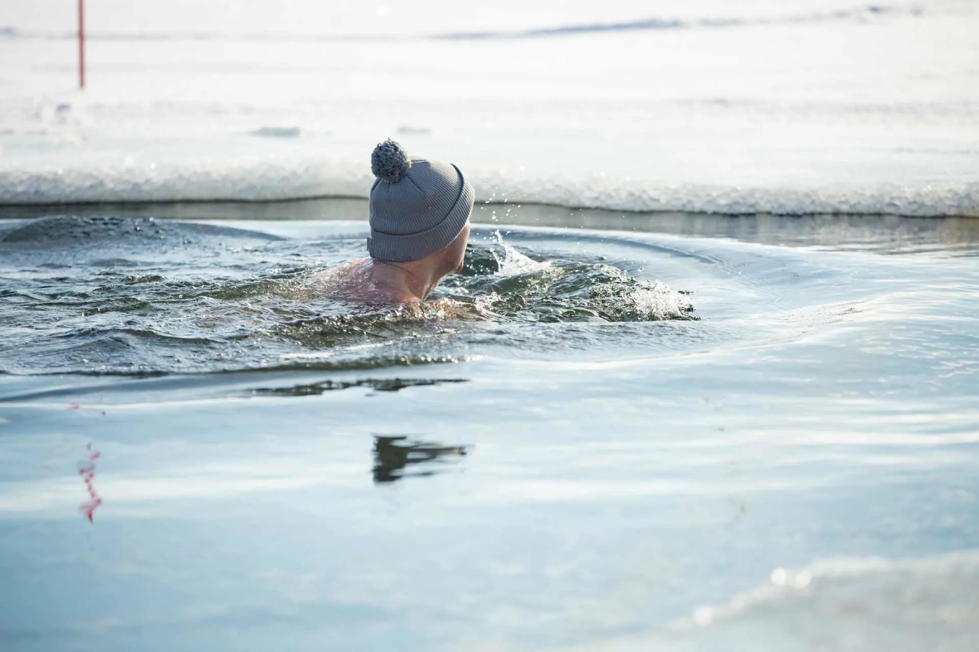 man building emotional resilience swimming in ice hole